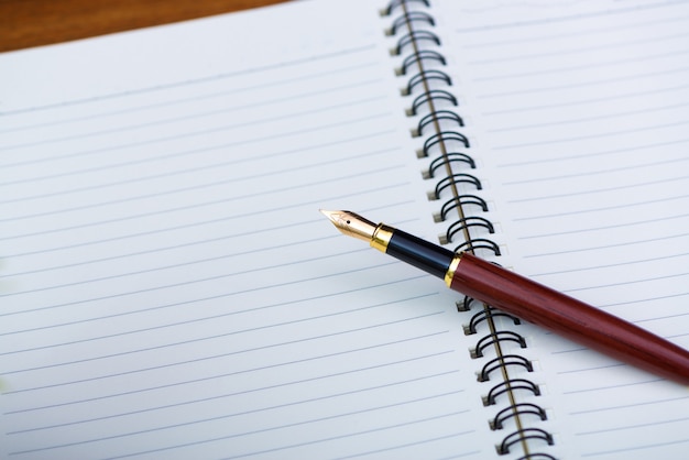 Gros plan d&#39;un stylo plume ou stylo à encre avec du papier de cahier