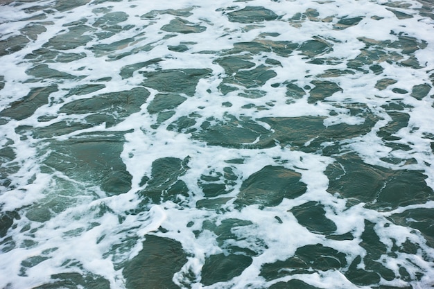 Gros plan sur la surface de l'eau de mer avec de la mousse