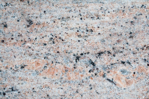 Photo un gros plan d'une surface de granit avec une couleur rose et orange.