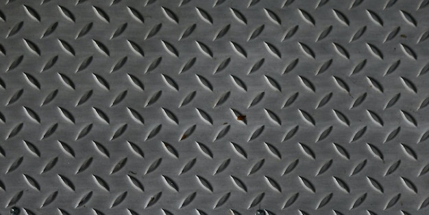 Un gros plan d'une surface métallique avec un motif en losange.