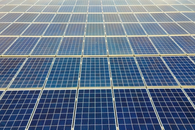 Photo gros plan de la surface des panneaux solaires photovoltaïques bleus montés sur le toit du bâtiment pour produire de l'électricité écologique propre. production de concept d'énergie renouvelable.