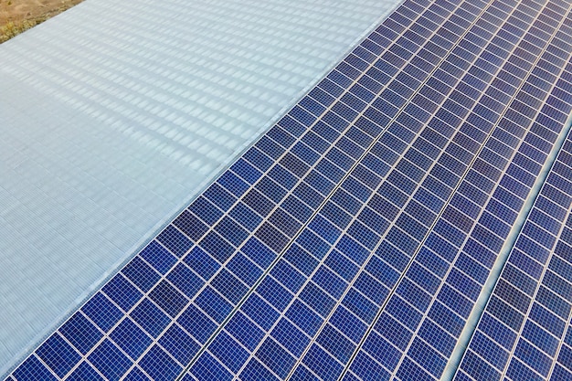 Gros plan de la surface des panneaux solaires photovoltaïques bleus montés sur le toit du bâtiment pour produire de l'électricité écologique propre. Production de concept d'énergie renouvelable.