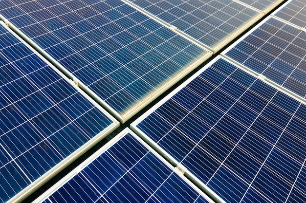 Gros plan de la surface des panneaux solaires photovoltaïques bleus montés sur le toit du bâtiment pour produire de l'électricité écologique propre. Production de concept d'énergie renouvelable.