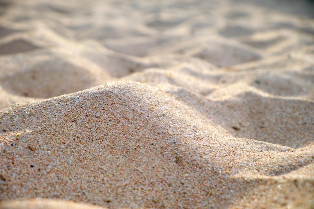 Gros plan sur une surface de sable jaune propre couvrant une plage de bord de mer éclairée par la lumière du jour Concept de voyage et de vacances