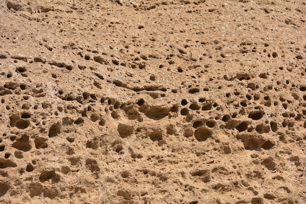 Un gros plan d'une surface de sable avec des trous.