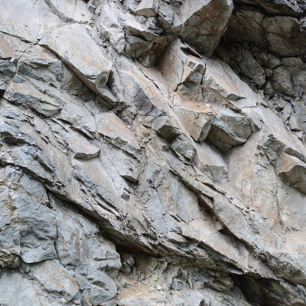 Gros plan de la surface de la texture de la roche abstraite avec des fissures et des copeaux.