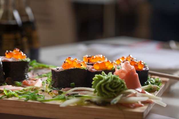 Gros plan de sushi servi sur une planche de bois.