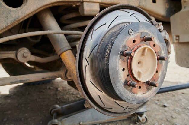 Gros plan sur un système de freinage de voiture ancien, usé et rouillé. Frein à disque arrière d'une voiture avec une roue retirée. Mise au point peu profonde.