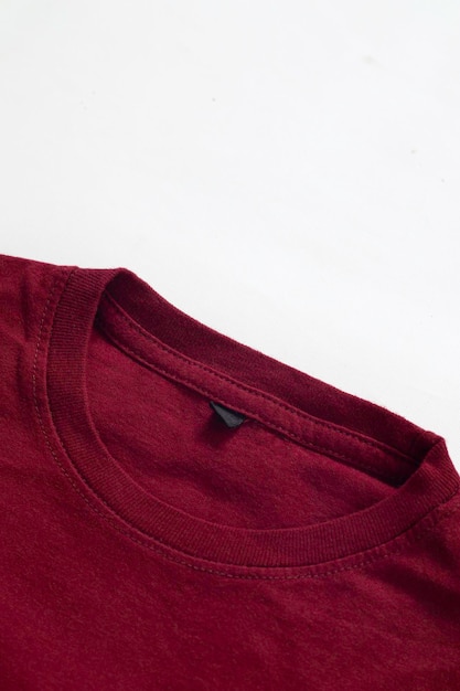 Gros plan d'un t-shirt rouge foncé plié avec un fond blanc