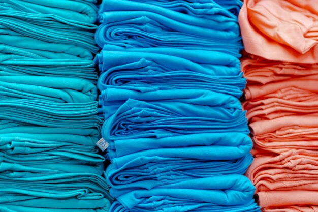 Gros plan de t-shirts colorés empilés sur des étagères