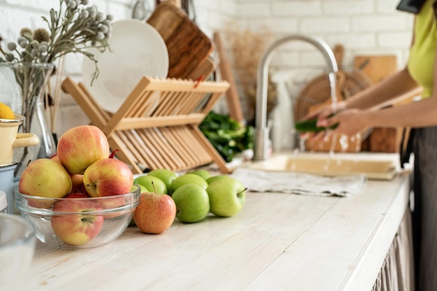 Gros plan de table avec des légumes verts et des fruits frais dans la cuisine