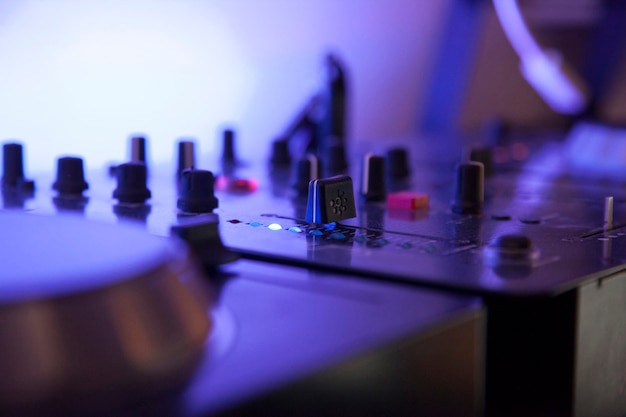 Gros plan d'une table de mixage de musique avec lumière LED bleue