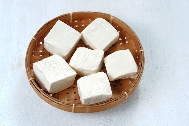 Gros plan de tahu putih cru ou de tofu dans un panier de bambou