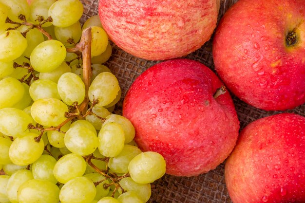 Un gros plan d'un tas de fruits dont une pomme rouge et une pomme rouge.