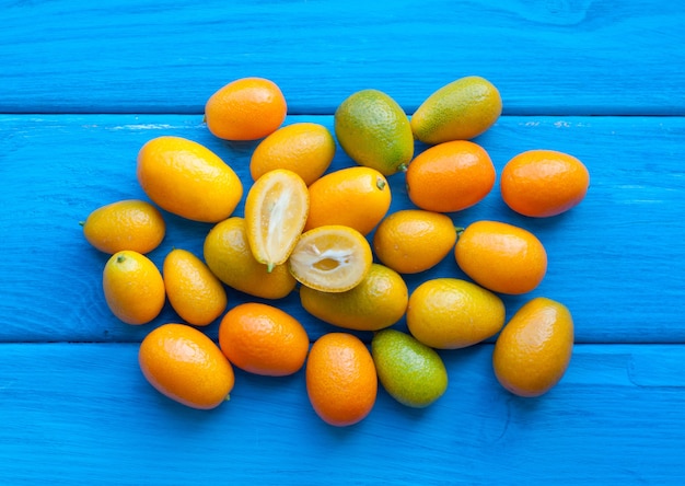 Gros plan sur le tas de fruits Kumquat sur bleu