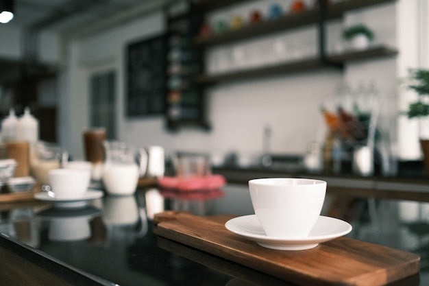 Gros plan tasse blanche de café chaud sur la table au café