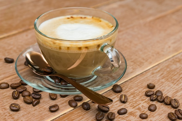 Gros plan d'une tasse de café chaud avec du lait sur un fond en bois. latte ou cappuccino sur une table