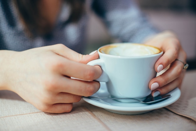 Gros plan d&#39;une tasse de café dans les mains d&#39;une femme.