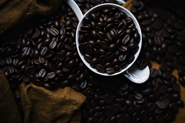 Gros plan d'une tasse de café débordante avec des grains frais ajoutant une touche de tradition à la saveur du café Généré par AI