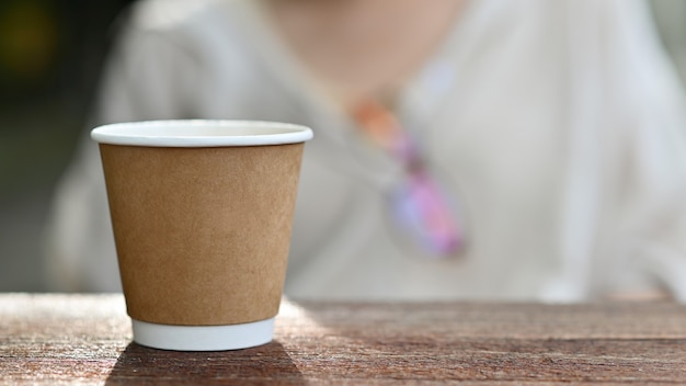 Gros Plan D'une Tasse De Café à Emporter Placée Sur Une Table En Bois.