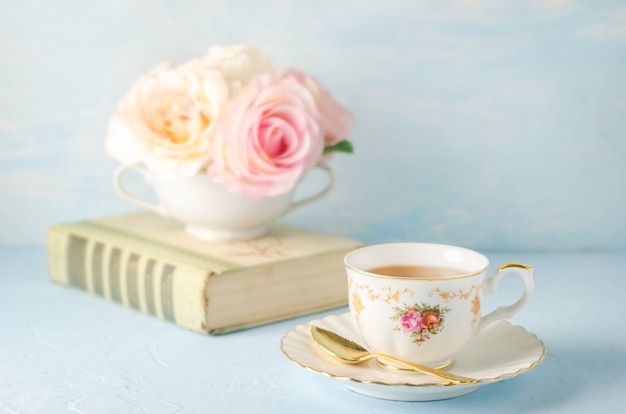 Photo gros plan, de, tasse thé, à, fleurs, et, livre, sur, bleu