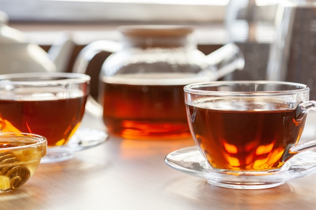 Gros plan d'une tasse de thé en verre avec du miel