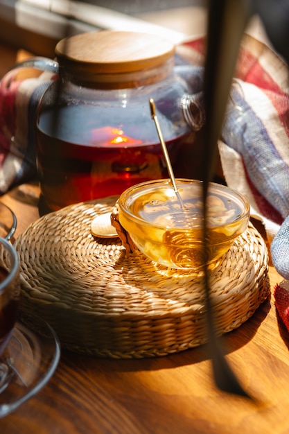 Gros plan d'une tasse de thé en verre avec du miel