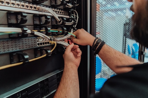 Gros plan sur un technicien configurant le réseau dans la salle des serveurs.