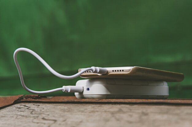 Gros plan sur téléphone mobile avec banque d'alimentation tenue en main