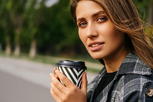 Gros plan sur la tête d'une femme blonde qui l'apprécie pour aller prendre un café à l'extérieur