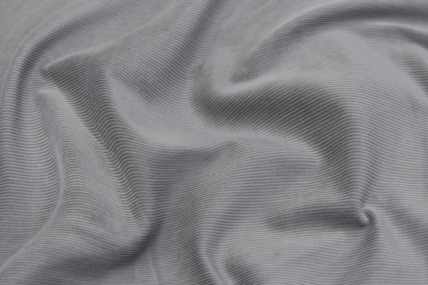 Gros plan sur la texture du tissu pour manteau. Tissu en laine grise. Fond gris.