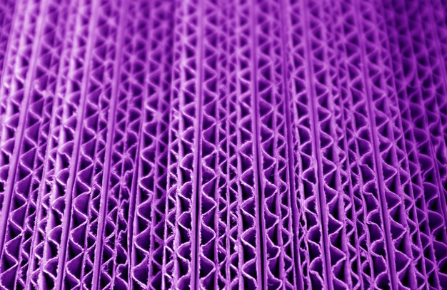 Gros plan de la texture de la pile de boîtes de papier ondulé de couleur violet déplier