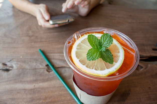 Gros plan de thé glacé au citron sur une table en bois