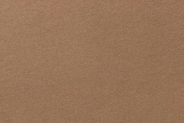 Gros plan de tissu en daim mat marron clair. Texture velours de feutre.