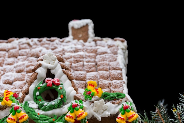 Gros Plan D'un Toit De Maison En Pain D'épice Fait Maison Recouverte De Neige De Noël Sur Fond Sombre. Maquette Pour Les Offres Saisonnières Et La Carte Postale De Vacances