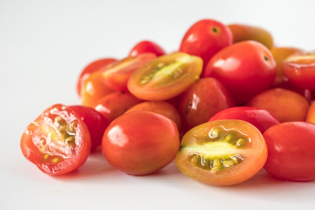 Gros plan de tomates prunes fraîches sur fond blanc.