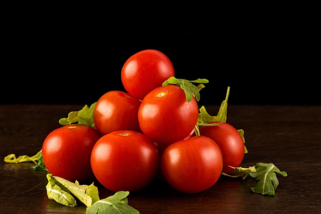 Gros plan de tomates rouges sur une table en bois isolée sur fond sombre