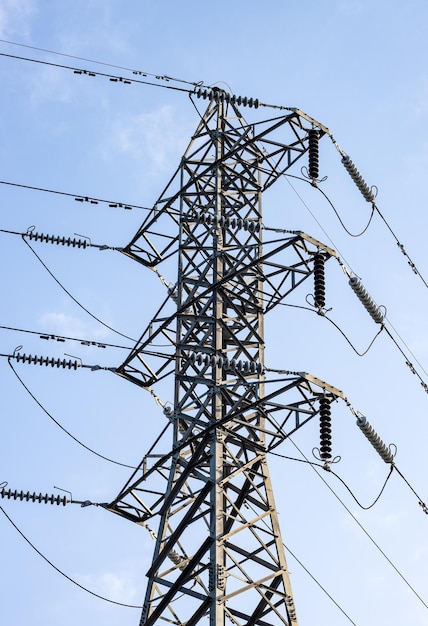 Gros plan de la tour de transmission d'électricité haute tension sous le ciel bleu vif