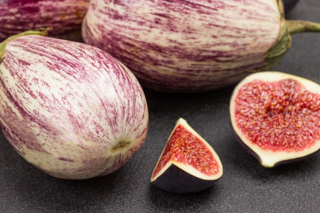 Gros plan de tranches d'aubergines et de figues à rayures. Fond noir