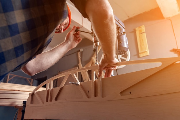 Gros plan d'un travailleur de la construction à l'aide d'une perceuse à bois Perceuse sur la table lors de travaux de rénovation à domicile Concepts de réparation à domicile gros plan