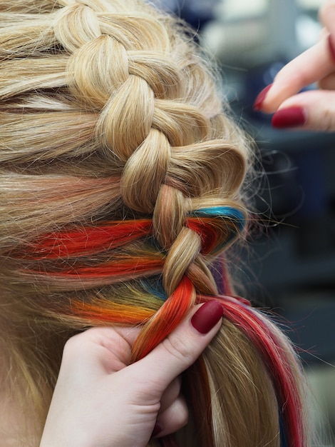 Gros plan de tressage. Cheveux arc-en-ciel en tresse.