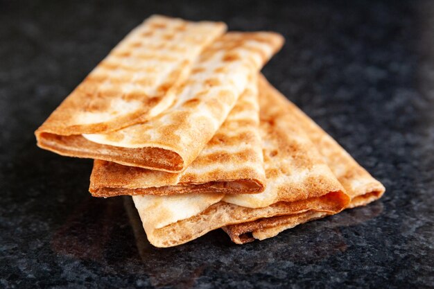 Gros plan de trois biscuits croquants empilés sur du marbre noir Biscuits fraîchement cuits