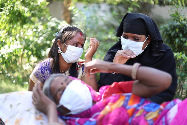 Gros plan de trois femmes indiennes avec des masques blancs sur le fond du parc