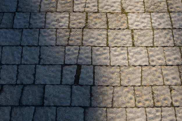 Gros plan d'une tuile polygonale grise de rue avec des détails en relief. Motif de carreaux