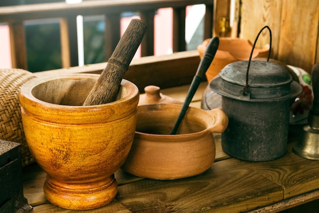 Gros plan d'ustensiles de cuisine fabriqués à la main sur une table en bois dans une maison rurale