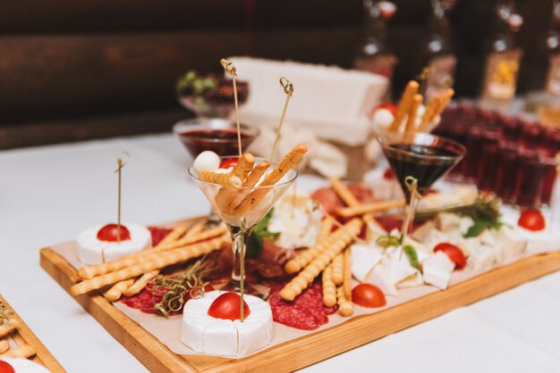 Gros plan d&#39;une variété de bâtons de pain, de charcuterie et de fromages, y compris du salami, du jambon, du brie et du camembert