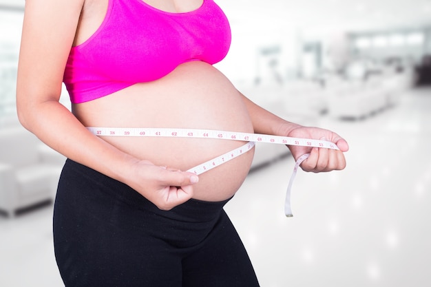 gros plan ventre de femme enceinte avec un ruban à mesurer à l&#39;hôpital