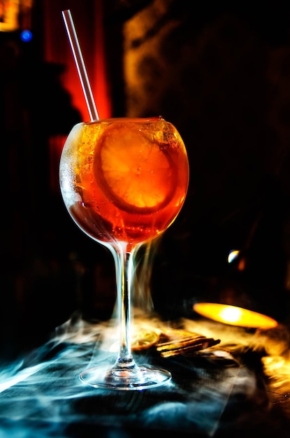Un gros plan d'un verre de vin au milieu de la fumée sur la table