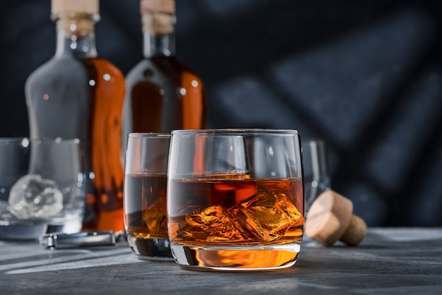 Gros plan de verres ronds de whisky avec de la glace sur la table