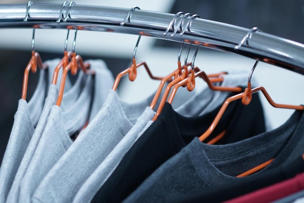 Un gros plan de vêtements accrochés en rangée